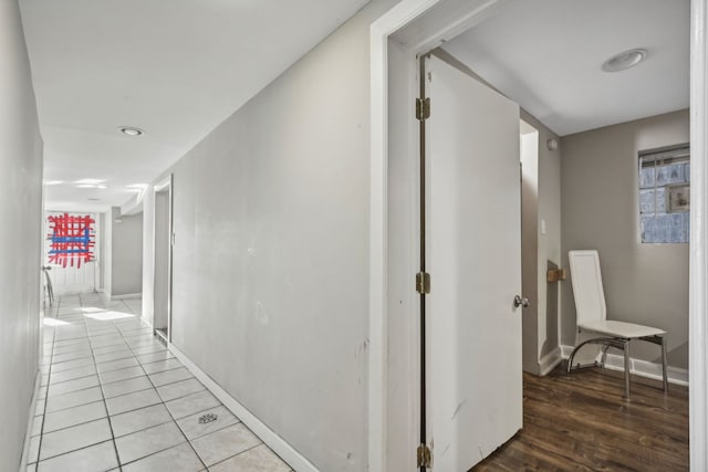 corridor with light wood-type flooring and baseboards