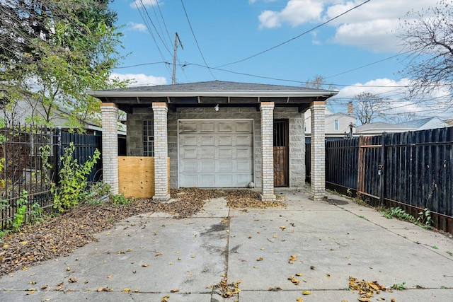 garage with concrete driveway and fence