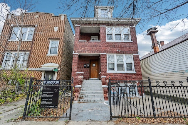 view of front of home featuring brick siding, a fenced front yard, and a gate