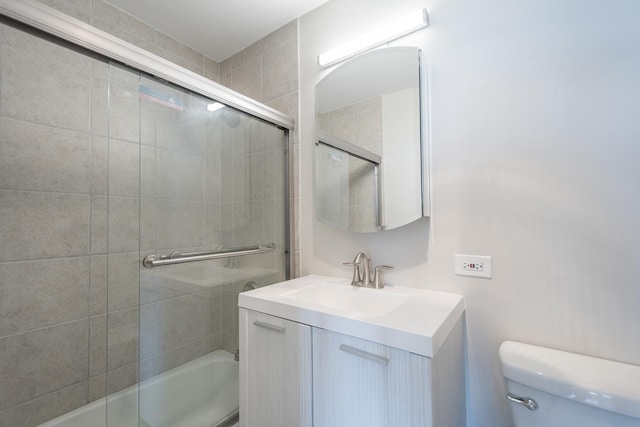 full bathroom featuring vanity, toilet, and bath / shower combo with glass door