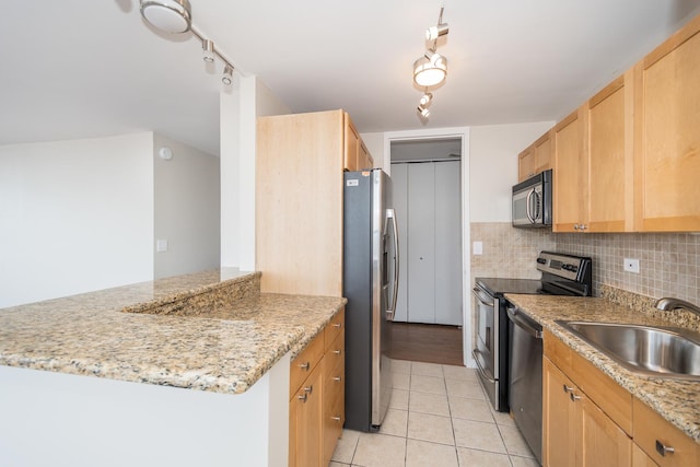 kitchen with light tile patterned floors, a sink, stainless steel appliances, light brown cabinetry, and backsplash