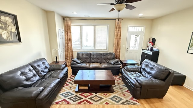 living room with light wood-style flooring, a ceiling fan, and recessed lighting