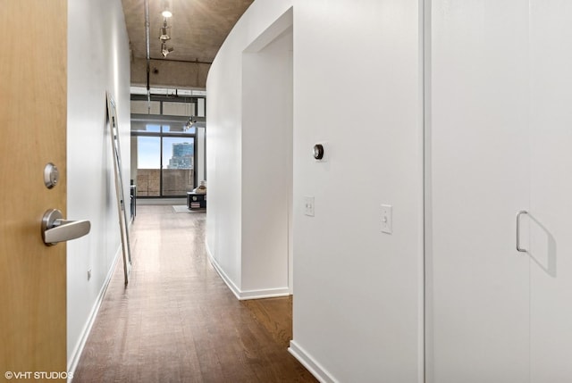 corridor with wood finished floors and baseboards