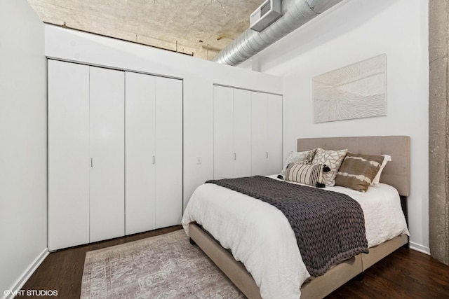 bedroom featuring wood finished floors and two closets