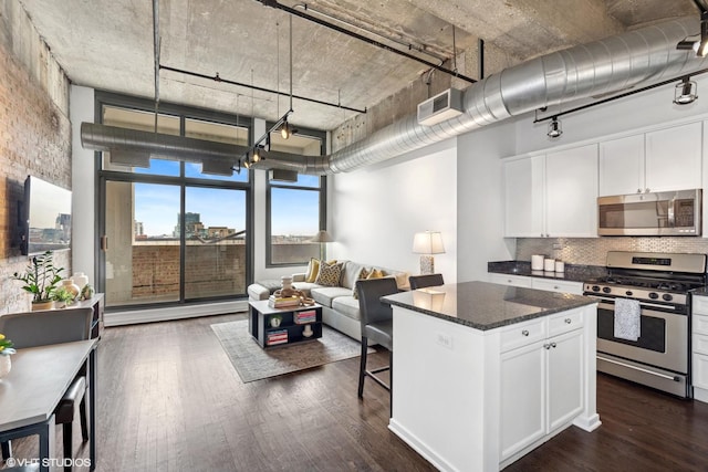 kitchen with stainless steel appliances, open floor plan, visible vents, and dark wood-type flooring