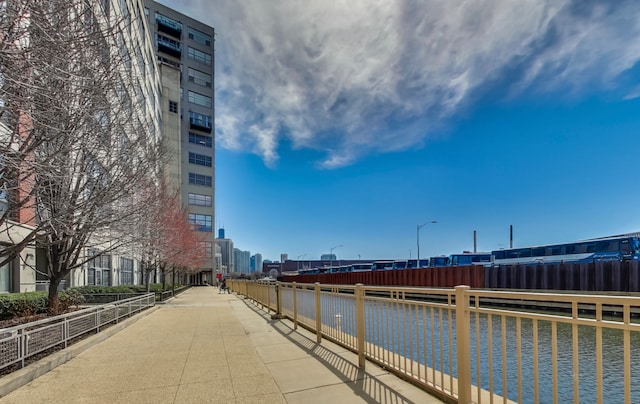 view of home's community featuring a water view, fence, and a city view