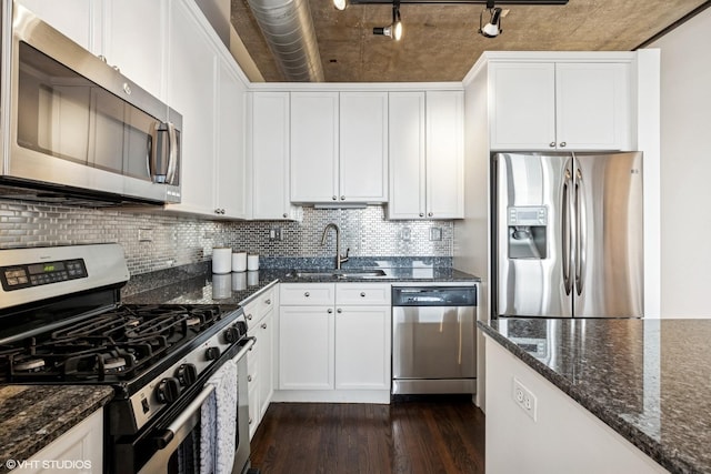 kitchen featuring white cabinets, dark wood-style flooring, stainless steel appliances, and backsplash