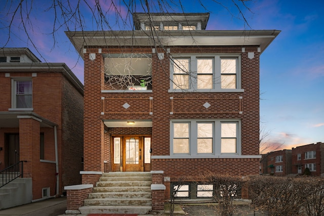 view of front facade featuring entry steps and brick siding