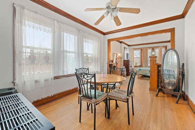 dining area featuring ceiling fan, ornamental molding, light wood-style flooring, and baseboards