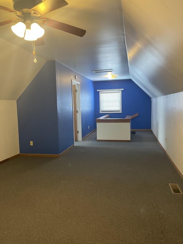 bonus room with lofted ceiling, baseboards, visible vents, and dark carpet