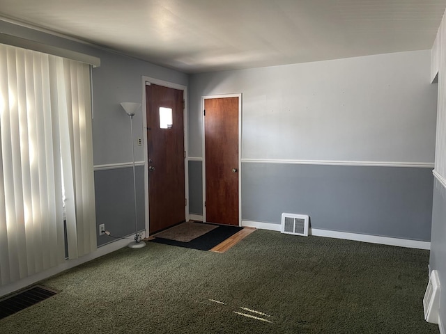 entryway with carpet floors, visible vents, and baseboards