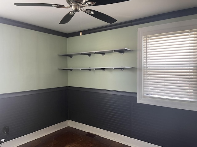 spare room with a wainscoted wall, plenty of natural light, and ornamental molding