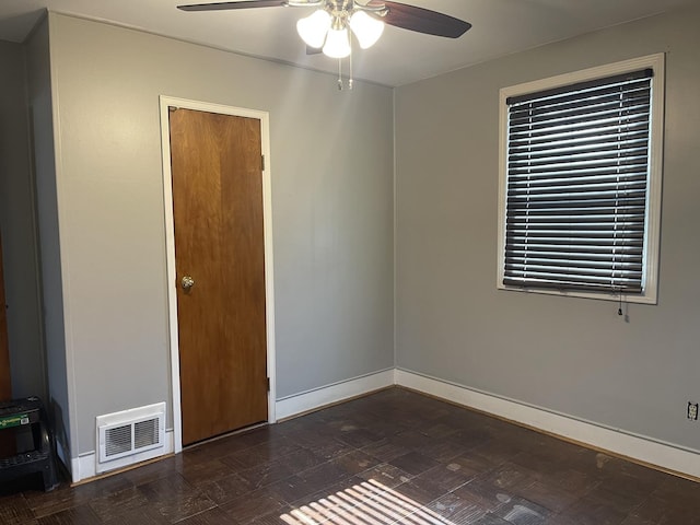 unfurnished room featuring visible vents, ceiling fan, and baseboards