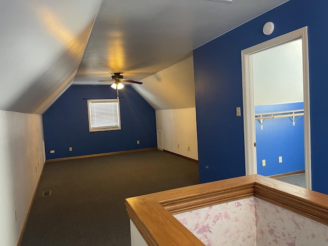 additional living space with visible vents, baseboards, a ceiling fan, carpet, and vaulted ceiling