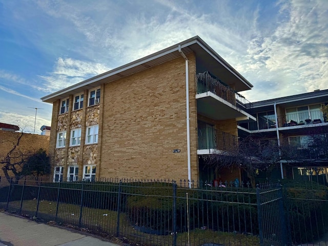 view of property exterior with brick siding and fence