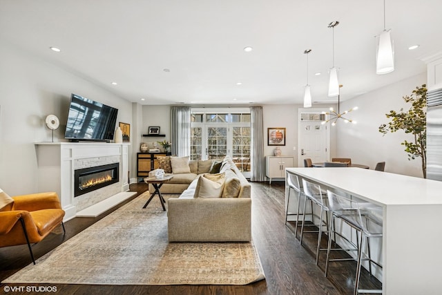 living area with dark wood finished floors, a glass covered fireplace, recessed lighting, and a wealth of natural light