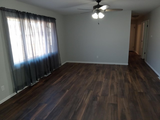 unfurnished room with ceiling fan, baseboards, and dark wood-style flooring