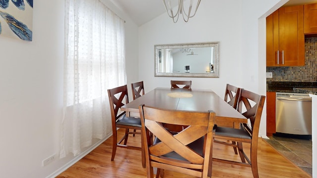 dining space with vaulted ceiling and light wood-type flooring