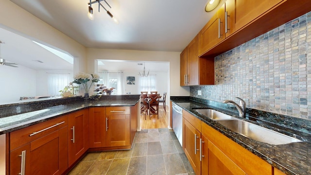 kitchen with dark stone counters, brown cabinetry, and dishwasher