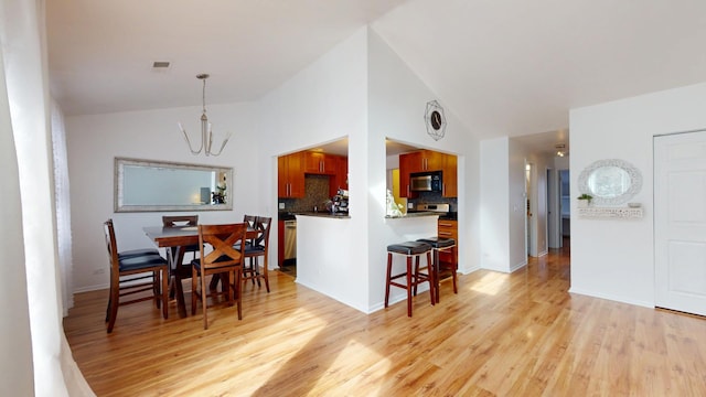 dining space with high vaulted ceiling, a notable chandelier, visible vents, baseboards, and light wood finished floors