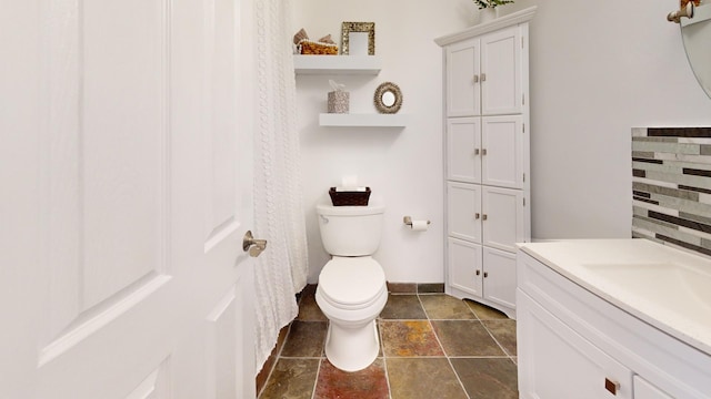 full bathroom featuring baseboards, vanity, and toilet