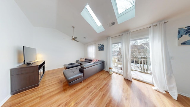 living area with ceiling fan, light wood finished floors, a skylight, and visible vents