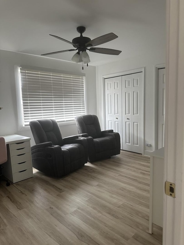 living area with light wood-style floors, a ceiling fan, and a wealth of natural light