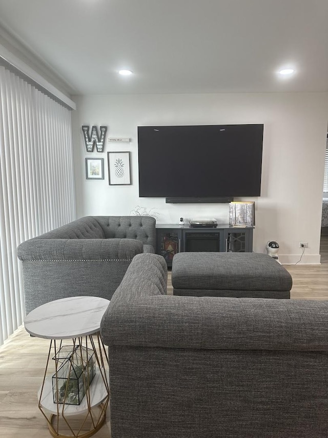 living area with recessed lighting, baseboards, and light wood finished floors