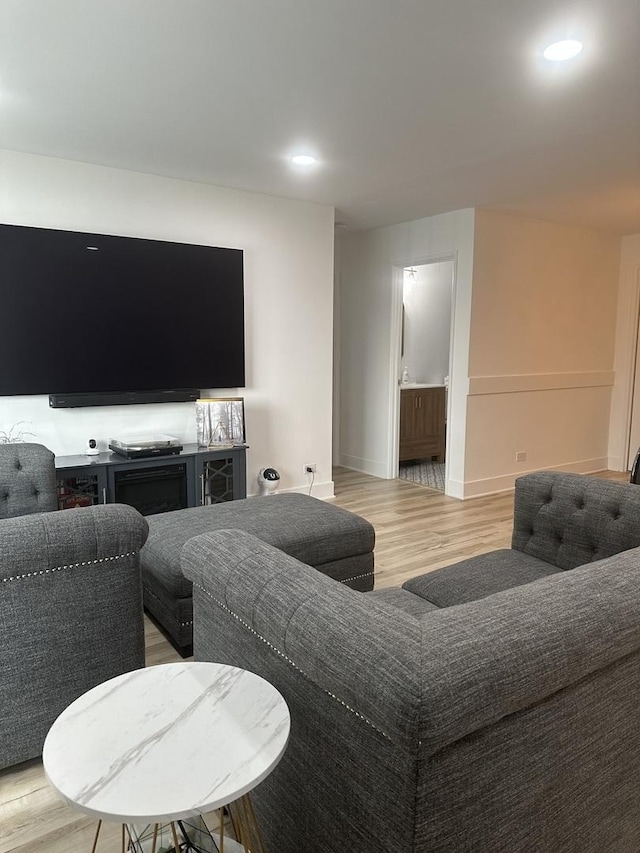 living room with light wood-type flooring, baseboards, and recessed lighting