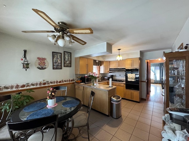 kitchen featuring a healthy amount of sunlight, hanging light fixtures, a peninsula, and black appliances