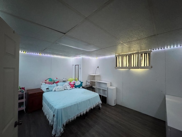 bedroom with dark wood-style floors and a paneled ceiling