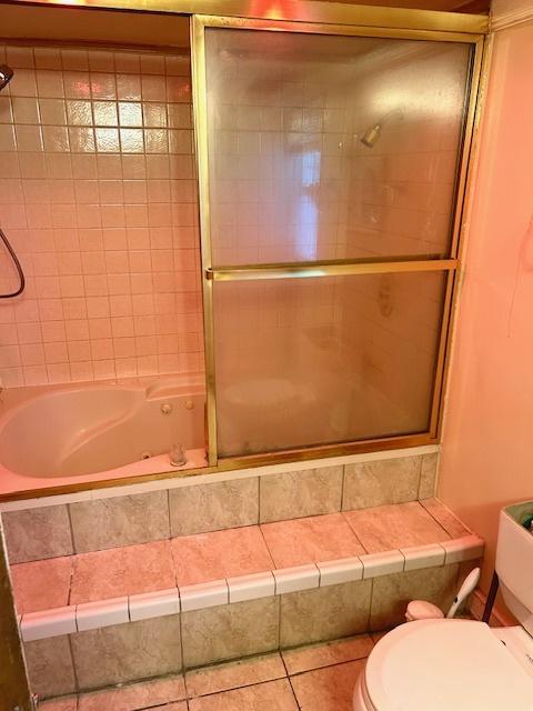 bathroom featuring toilet, tiled shower / bath, and tile patterned floors