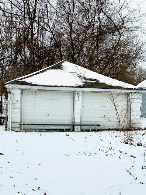 snow covered garage featuring a garage