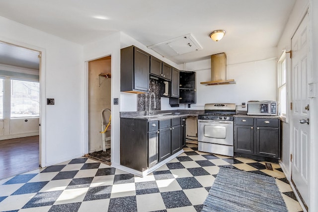 kitchen featuring dark floors, open shelves, appliances with stainless steel finishes, a sink, and wall chimney exhaust hood