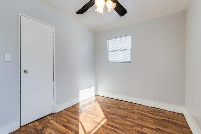 unfurnished room featuring a ceiling fan, wood finished floors, visible vents, and baseboards