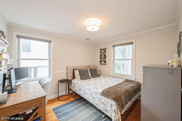 bedroom with light wood finished floors, baseboards, and ornamental molding