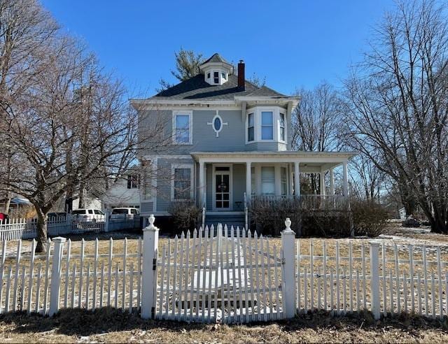 victorian-style house with covered porch, a fenced front yard, a chimney, and a gate