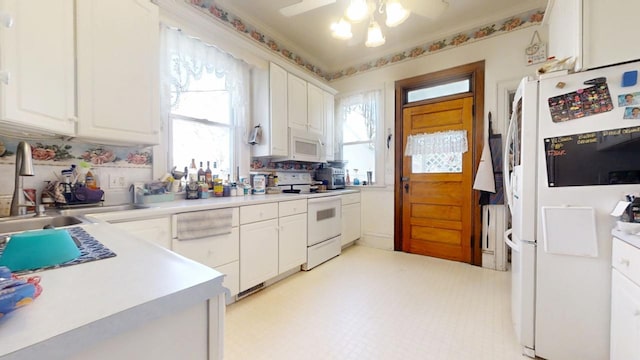 kitchen with light floors, white appliances, and white cabinetry