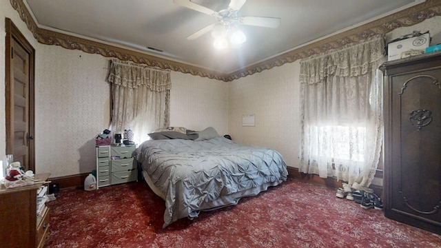 bedroom featuring wallpapered walls, multiple windows, visible vents, and ornamental molding