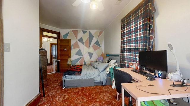 carpeted bedroom with an accent wall, ceiling fan, and wallpapered walls