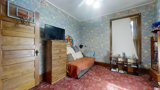 living area featuring crown molding, a ceiling fan, carpet flooring, baseboards, and wallpapered walls