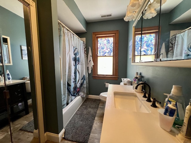 full bath with toilet, wood finished floors, visible vents, vanity, and baseboards