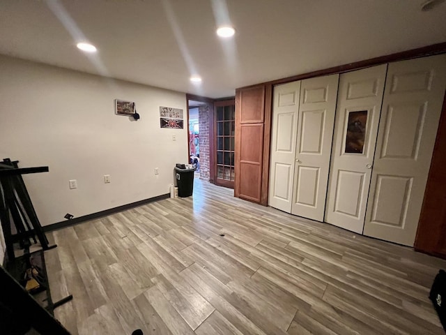 unfurnished bedroom with baseboards, a closet, recessed lighting, and light wood-style floors