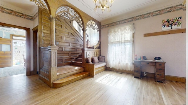 stairs featuring baseboards, a chandelier, and wood finished floors