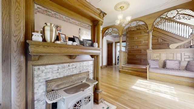 interior space featuring crown molding, stairway, light wood-style flooring, and an inviting chandelier