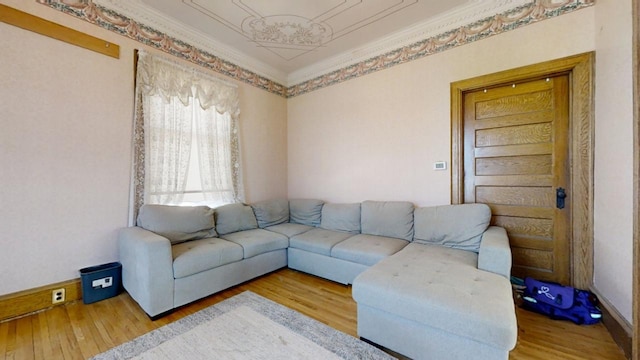 living room with baseboards, wood finished floors, and crown molding