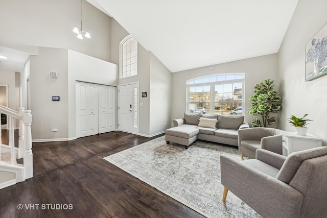 living room featuring baseboards, dark wood-style floors, stairs, high vaulted ceiling, and a notable chandelier