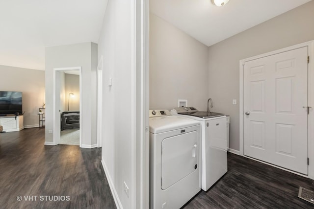 washroom featuring dark wood-style floors, laundry area, baseboards, and washing machine and clothes dryer