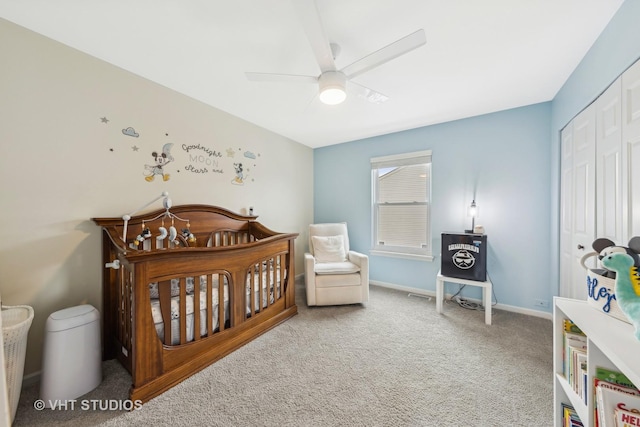 bedroom featuring baseboards, a ceiling fan, carpet flooring, a nursery area, and a closet