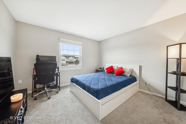 bedroom with light carpet and baseboards